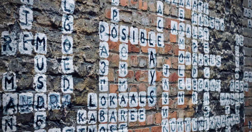 A graffiti of words on a brick wall, painted in the form of a crossword.