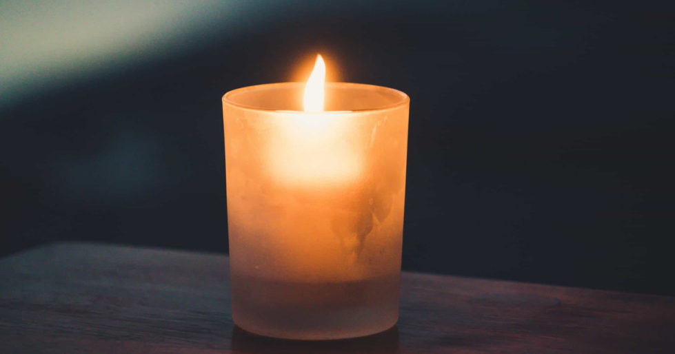 a close-up of a burning candle in a votive