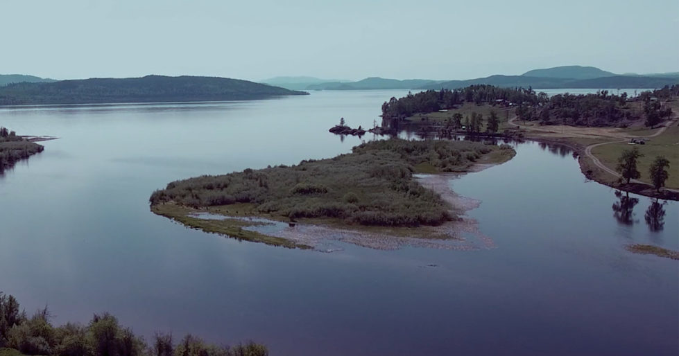 A lake with a green peninsula and an island in Nadleh