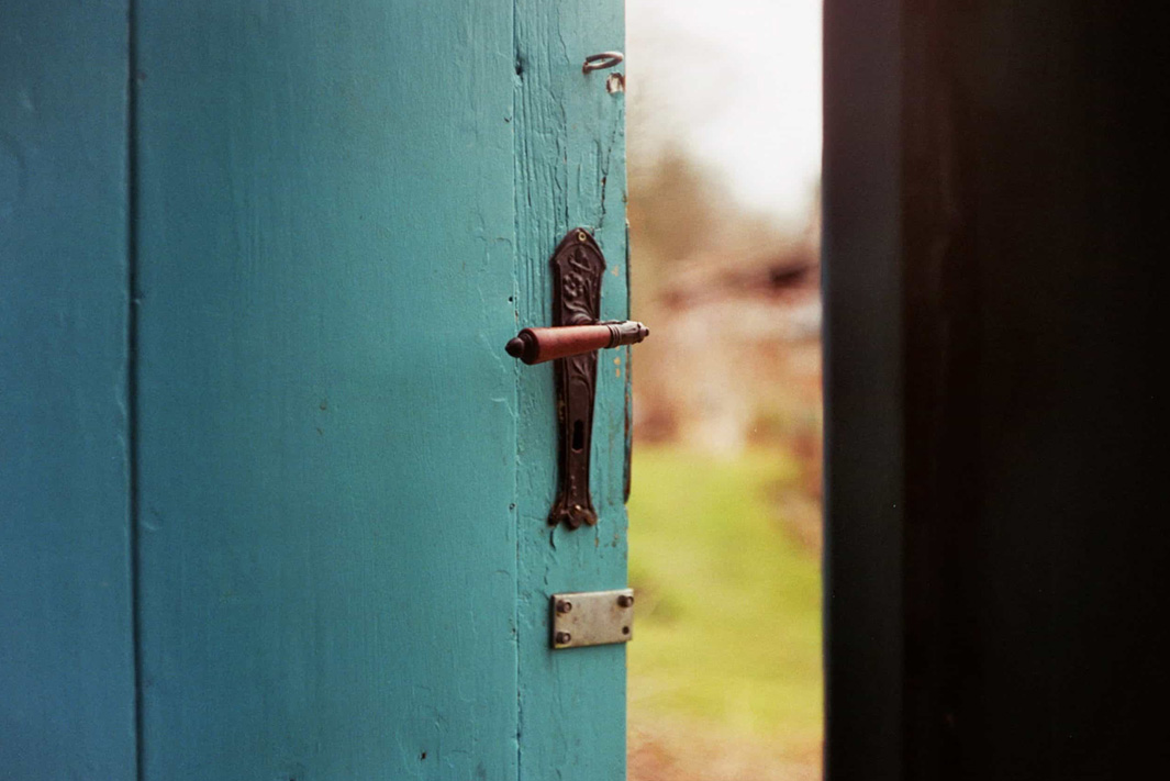 A close-up on the handle of a wooden blue door