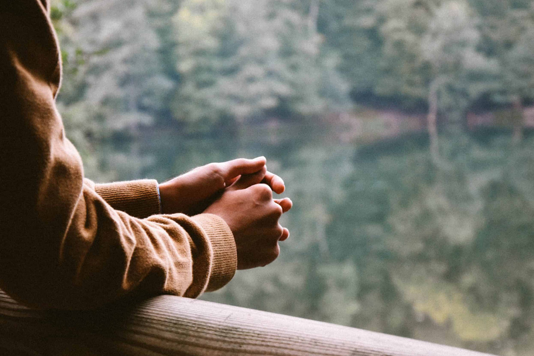 Hands clasped over a railing