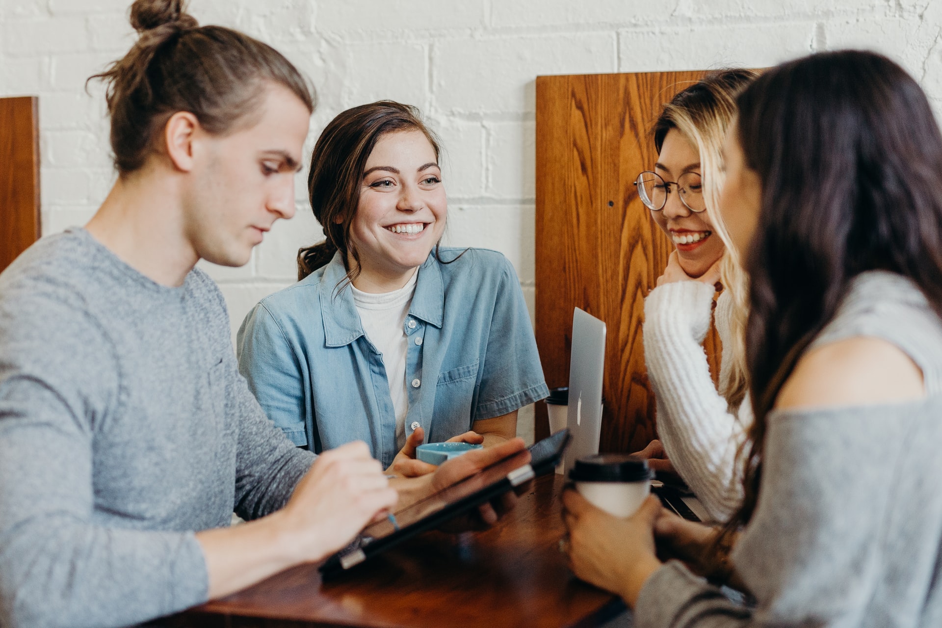 A group of people standing and interacting in a coffee shop