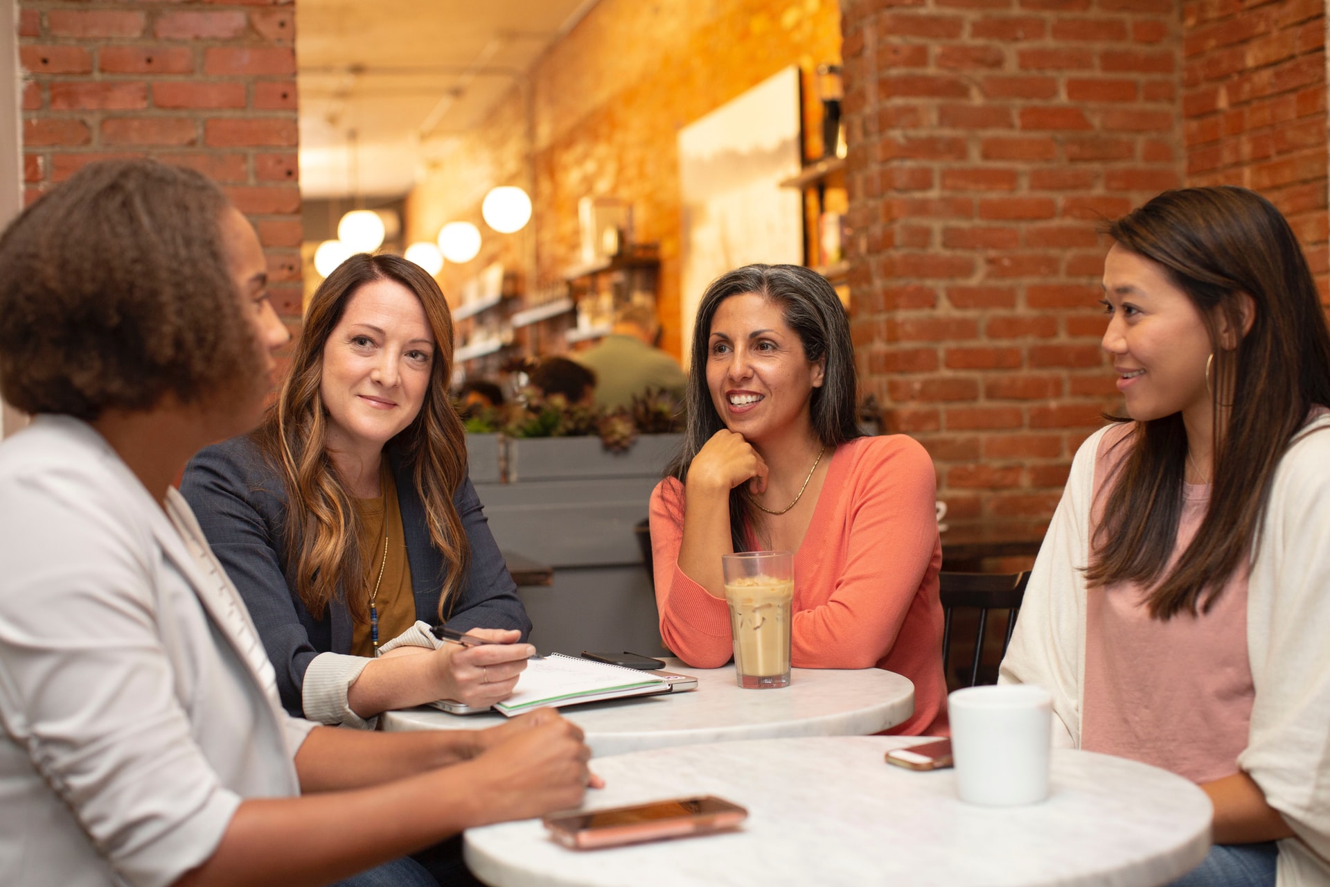 4 women in a coffee shop having a discussion